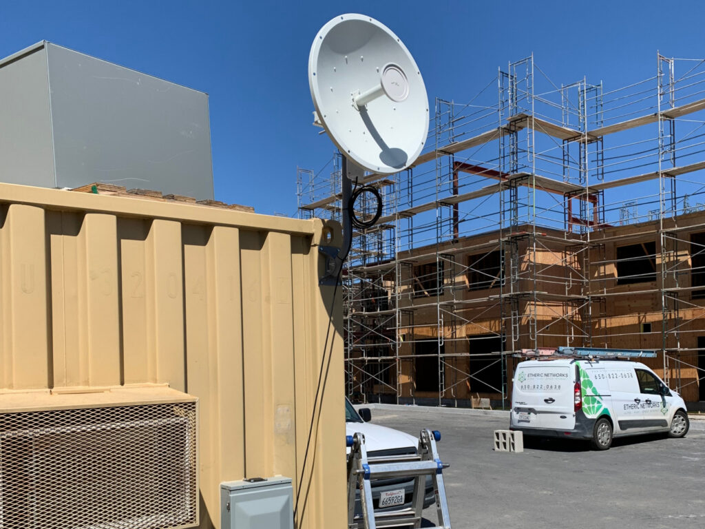 Etheric Networks installation of a construction site with a dish on the trailer, and our company van in the background.
